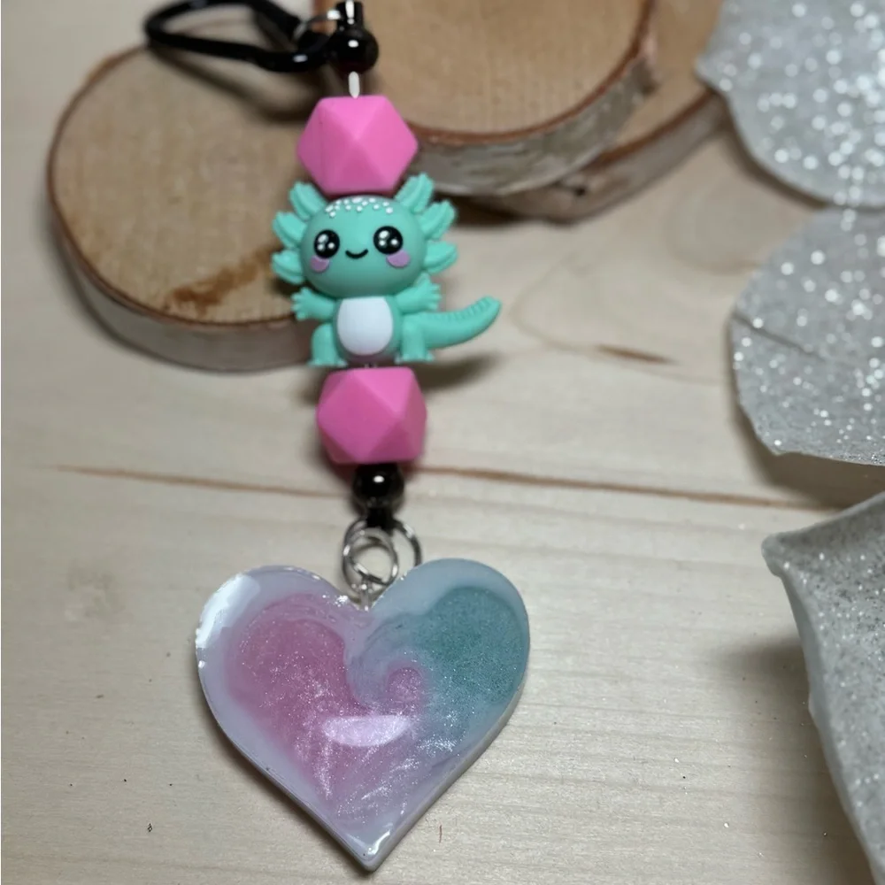 axolotl keychain with a pink and teal or blue resin heart pendant